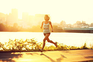 A woman running at sunrise.